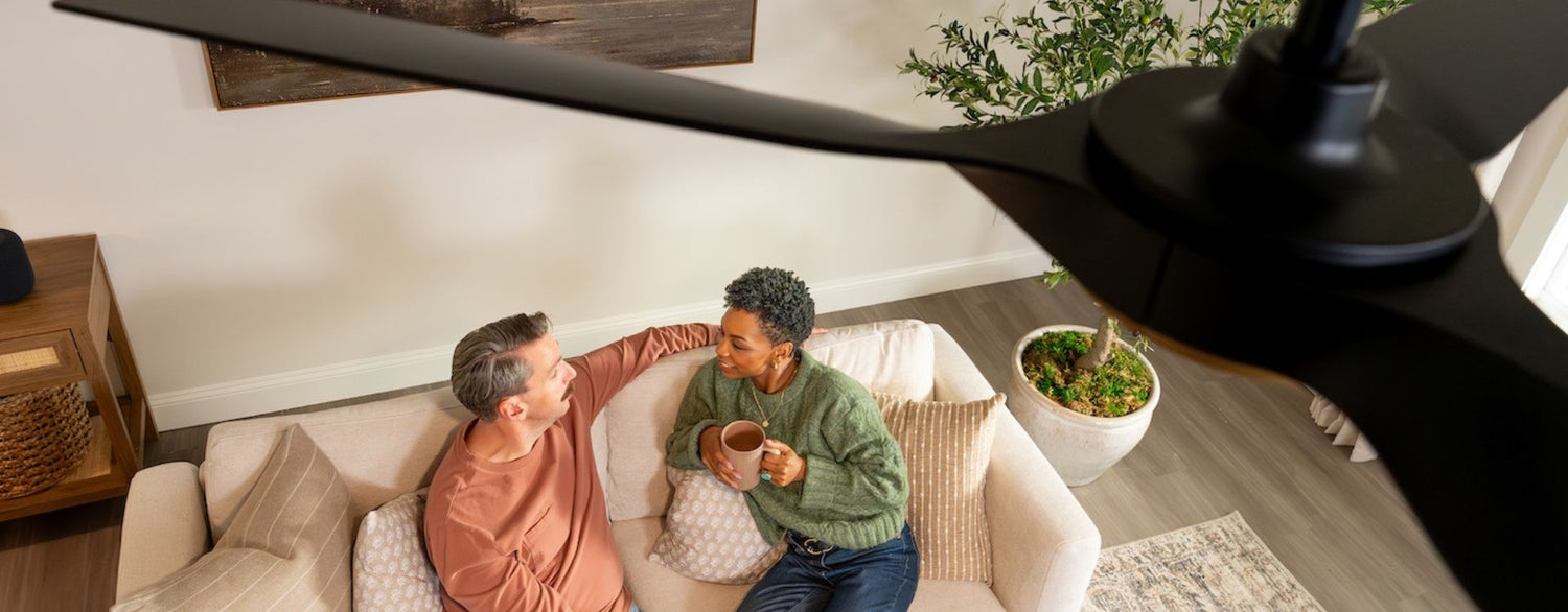 Top-down lifestyle shot of couple relaxing on sofa with ceiling fan overhead
