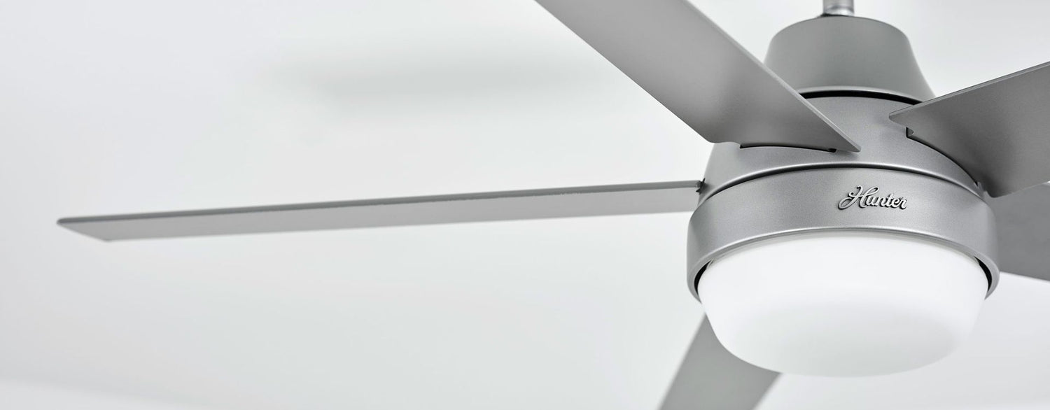 Close-up product shot of a contemporary silver ceiling fan with sleek blades and an integrated LED light, highlighting its clean, modern design and minimalist aesthetic.