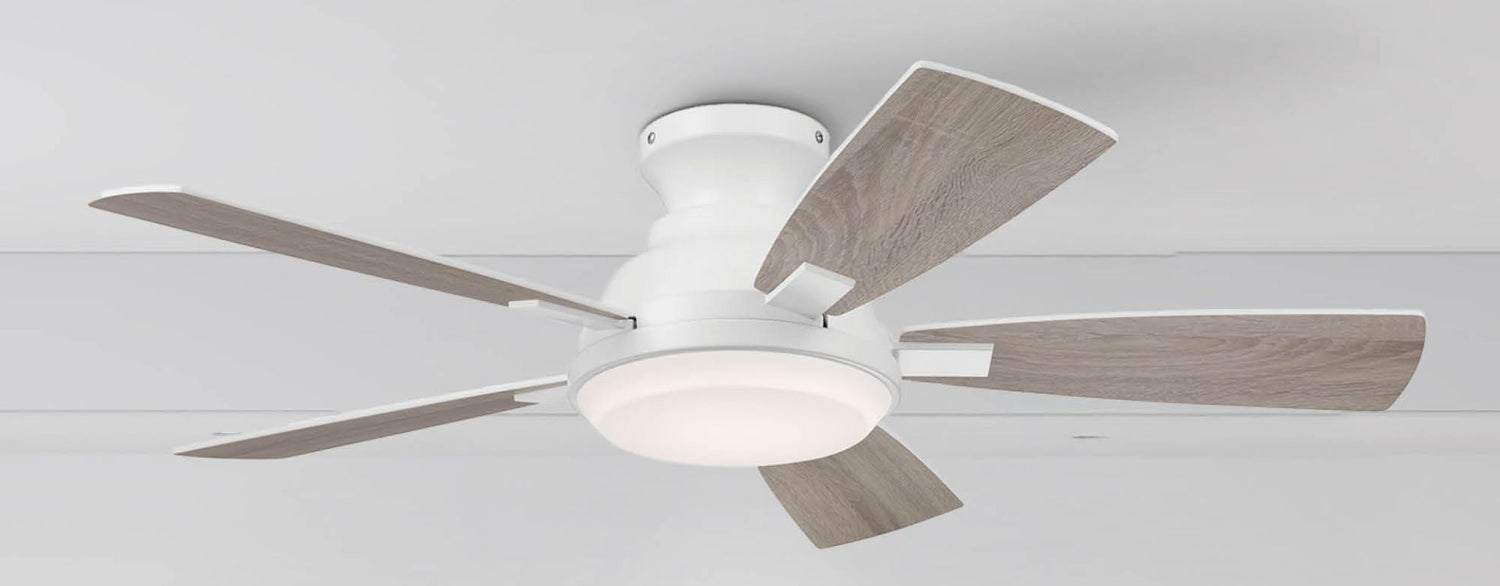 Modern white five-blade ceiling fan with light wood blades and integrated LED light, flush mounted on a white ceiling in a contemporary space