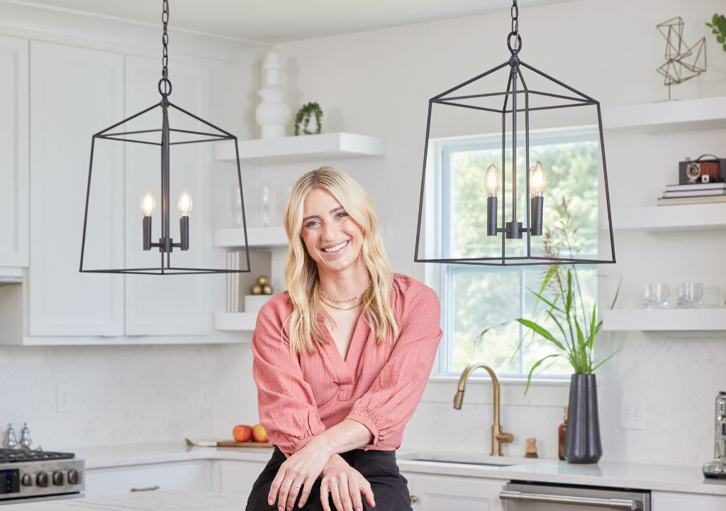 Jasmine Roth sitting on kitchen island between two Fair Oaks Lanterns in matte black finish.