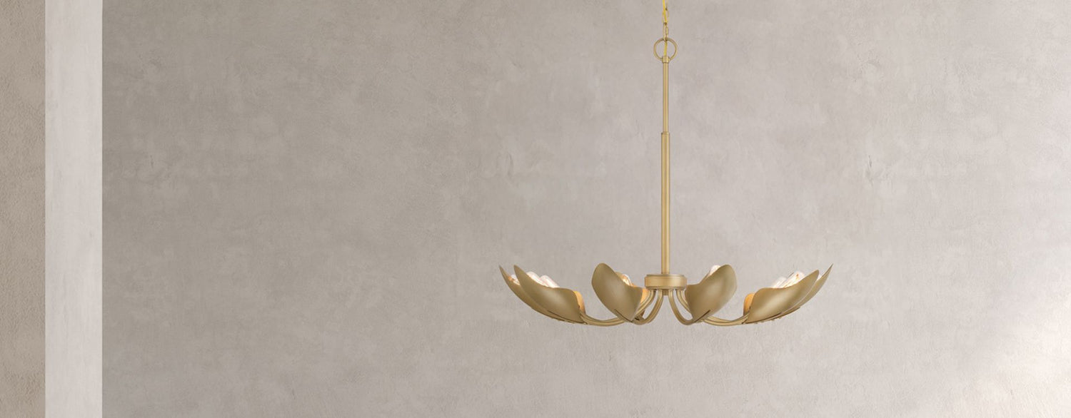 Gold chandelier hanging against a gray wall