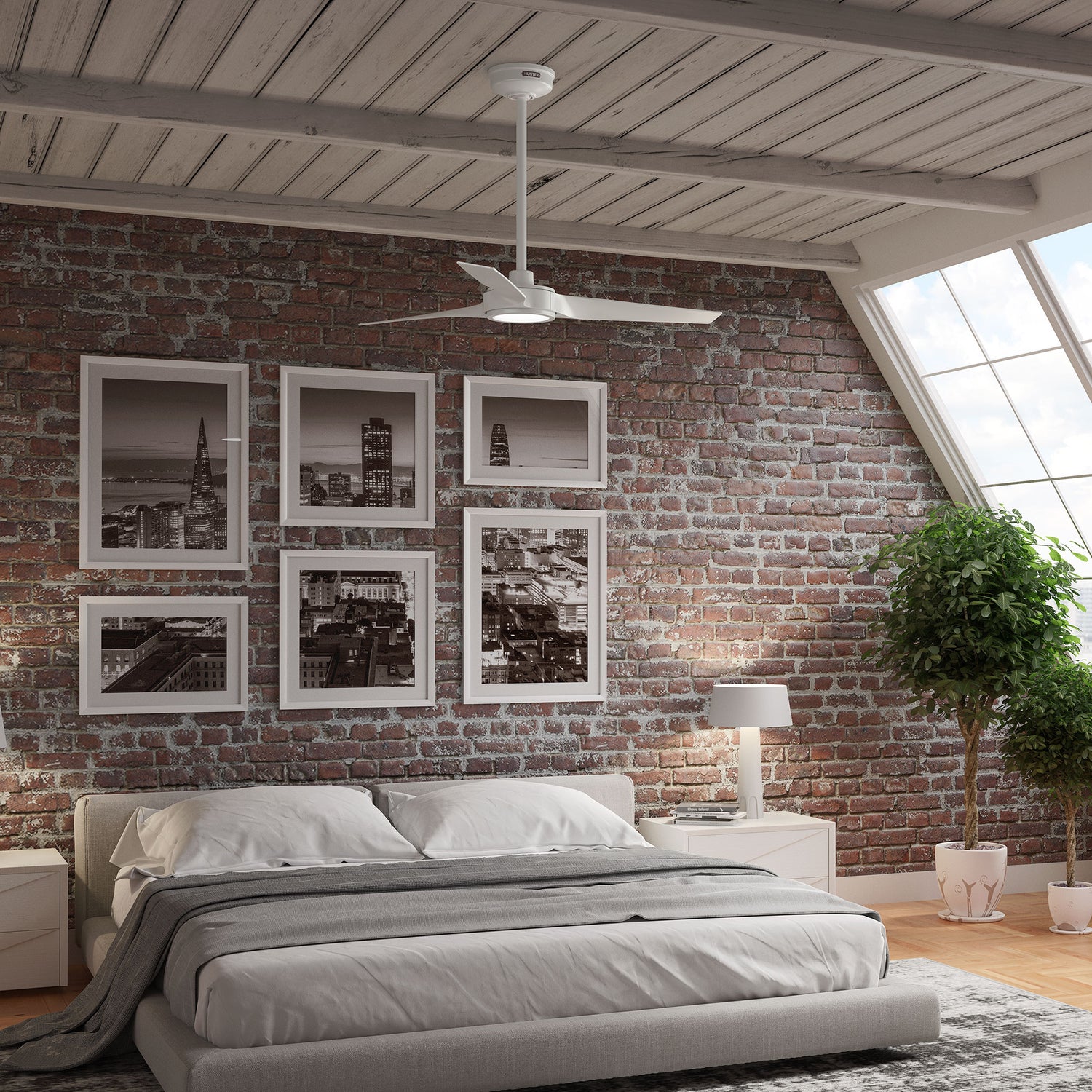Modern bedroom with brick wall, framed pictures, and the ZenTech 3 blade ceiling fan mounted with a downrod.