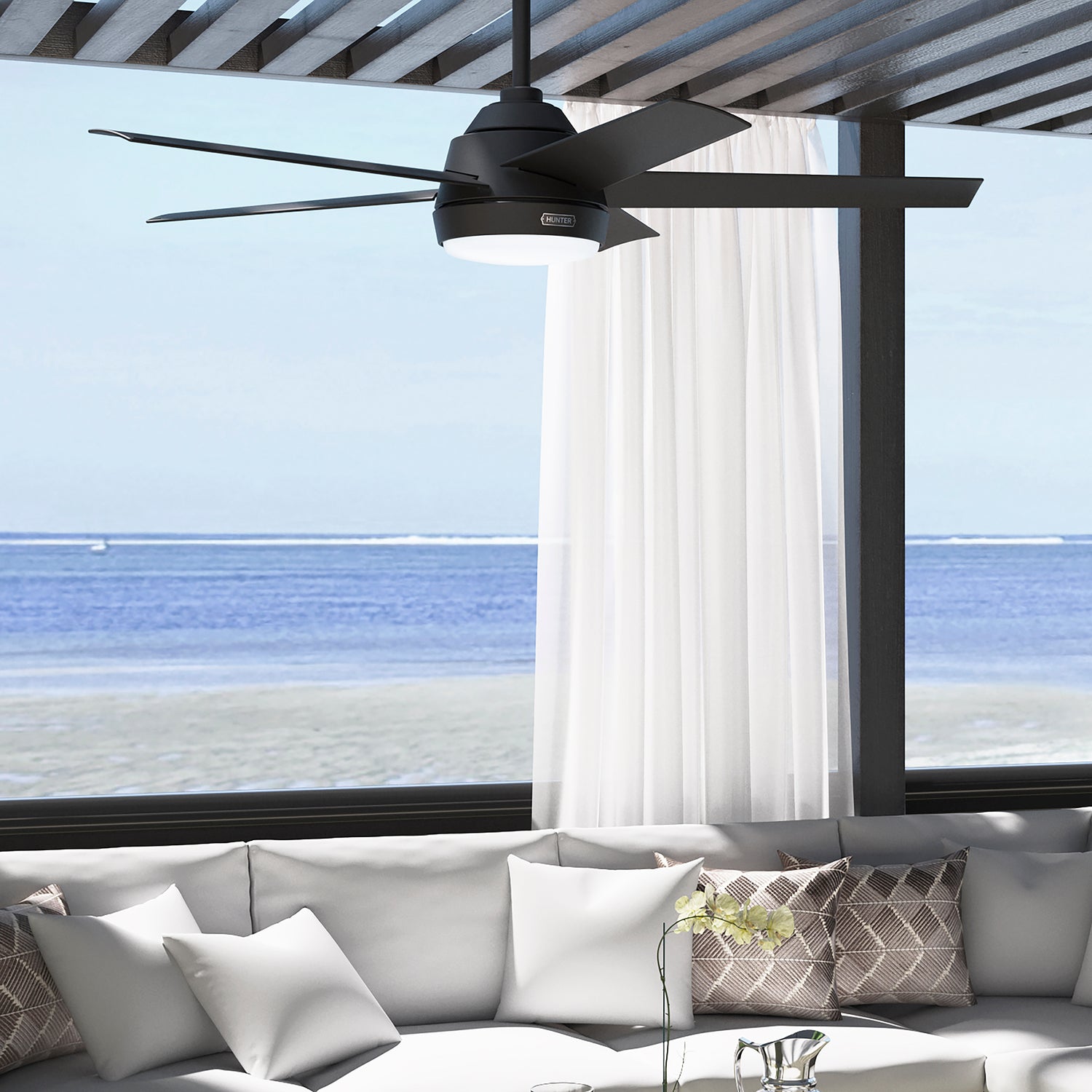 Skyflow Outdoor Ceiling fan mounted on pergola at the beach in a matte black finish.