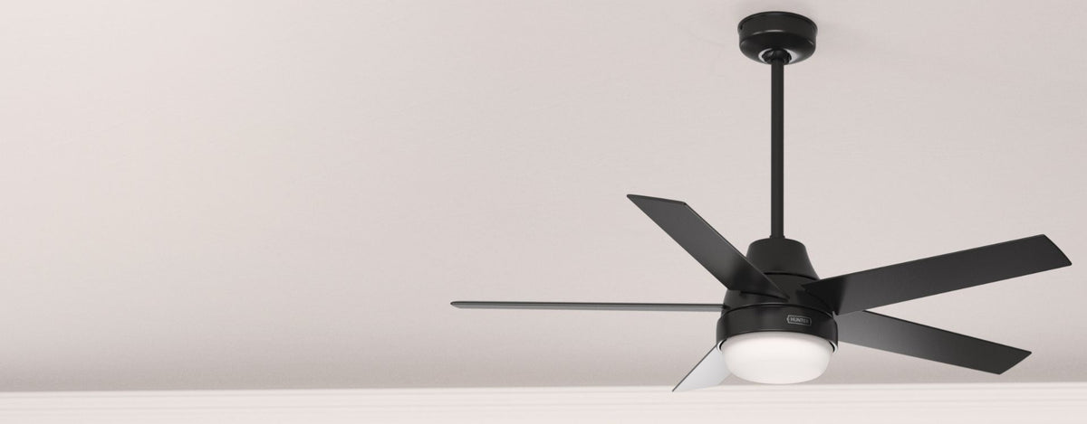 Product-focused image of a modern six-blade ceiling fan with an integrated LED light, finished in matte black and mounted with a downrod against a clean, neutral ceiling background.